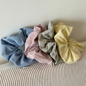Set of four corduroy scrunchies in blue, pink, grey and yellow for stylish hair styling