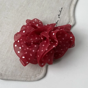 Macro shot of French style red mesh polka dot fabric hair clip with pleated organza layers