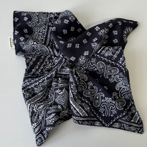 Close-up of navy blue paisley bandana fabric with a white handmade stitched label