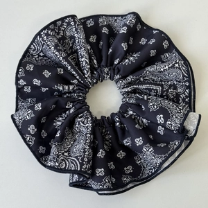 Close-up of navy paisley print scrunchie showing detailed textile texture and stitching