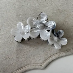 Vue détaillée de la pince à cheveux en acétate à motif marbré sur fond de lin