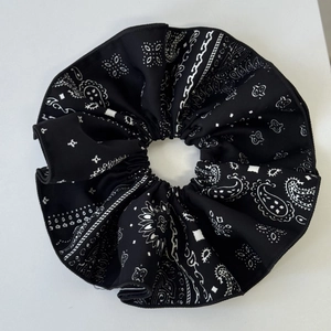 Detailed view of large navy paisley scrunchie with classic white pattern and premium texture