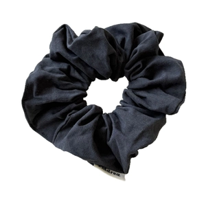 Dark grey pleated knit scrunchie for women with minimalist brand label on white background