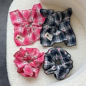 Elastici per capelli a scacchi blu e rosa con fragole su morbido sfondo bianco
