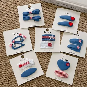 Handmade denim blue and red heart hair clips set with bows and lace on display card