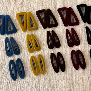 Detail view of colorful velvet hair clips in various geometric shapes with soft texture