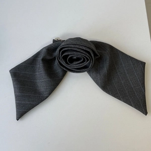 Detail of grey striped fabric hair claw with an elegant rose-shaped folded fabric design