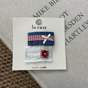 Detail of handmade hair clips set with denim ruffles, lace, and red heart button accents