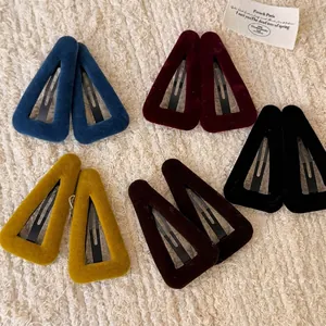 Set of 10 colorful velvet triangle BB hair clips in five elegant shades on a soft fabric base