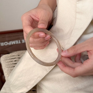 Detail showing the translucent brown acetate bangle texture with natural stone pattern