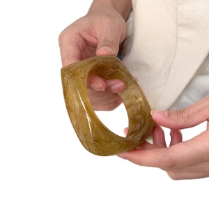 Chic amber tortoiseshell acetate bangle featuring a thick minimalist round design