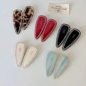 Elegant rhinestone-studded hair clips in assorted colors like leopard and burgundy