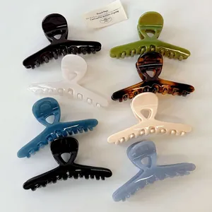Pinces à cheveux croisées en plusieurs couleurs brillantes sur un fond blanc pur