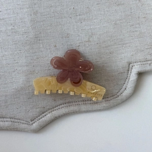 Pince à cheveux fleurie rose poudré élégante sur tissu en lin avec bordure ondulée