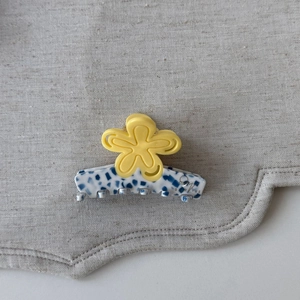 Détail macro de la pince à cheveux coréenne avec fleur jaune et motif marbré bleu