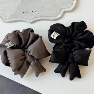 Elegant oversized fabric bow scrunchies in black and dark brown suit material
