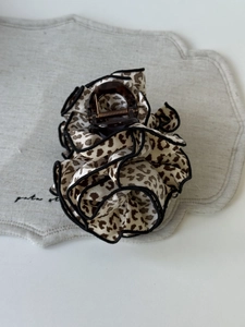 Detail of leopard print fabric scrunchie hair claw clip with brown resin finish