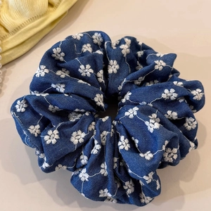 Chouchou bleu denim avec broderie florale blanche et texture de tissu élégante et froissée