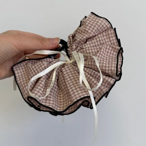 Detail of pink plaid fabric hair claw clip with elegant white silk ribbon streamers