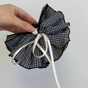 Close-up of blue and white checkered fabric bow hair clip with black lace trim details