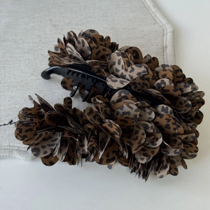 Detail of Korean leopard print fabric flower hair clip with black banana grip closure