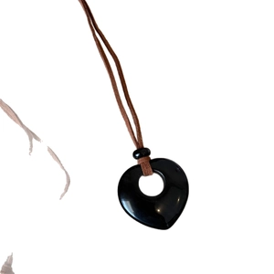 Collana minimalista con cuore traforato in pietra naturale nera e cordino marrone
