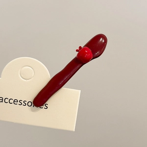 Close-up of deep wine red hair clip with a 3D red apple decor on a display card