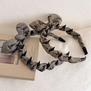 Chic knotted headband with bow pattern and edgy studs for elevated crown hairstyle