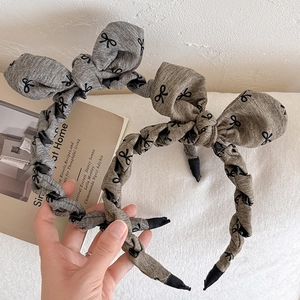 Grey bow headband with black knot pattern and non-slip teeth for elegant hair styling