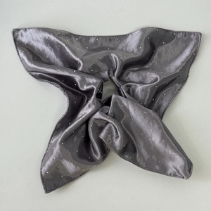 Detailed close-up of dark grey satin scrunchie with sparkling rhinestones decoration