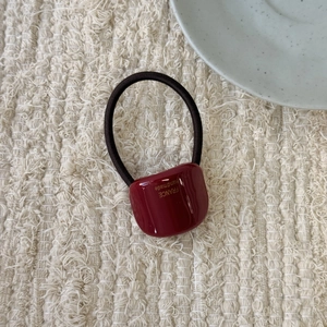 Detailed macro view of deep red resin square ornament on a high elastic hair tie