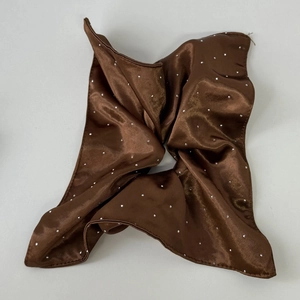 Detail of chocolate brown satin scrunchie with sparkling rhinestones and silk texture