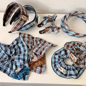 Blue and brown plaid hair accessory set with scrunchies and bow clips on white background