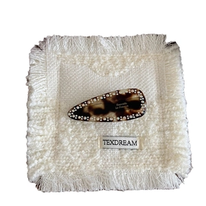Barrette goutte d'eau à motif léopard avec strass étincelants sur un fond de tissu blanc