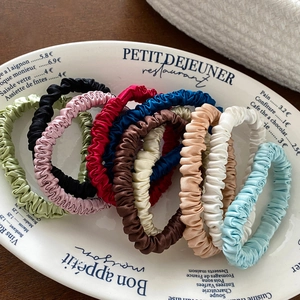 Satin silk hair scrunchie set in various colors displayed on a vintage floral ceramic plate