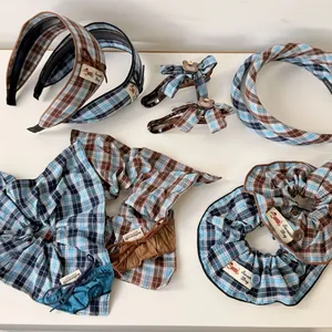 Blue and brown plaid hair accessory set including scrunchies and bow clips on white background