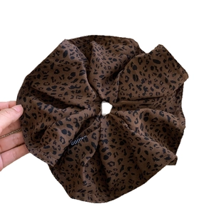 Oversized leopard print scrunchie for women with fashion tag on white background