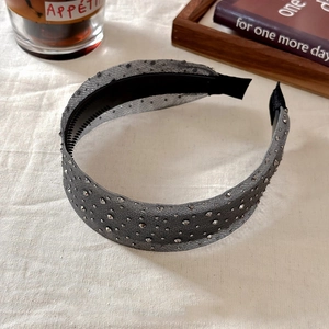 Close-up of grey mesh headband with sparkling rhinestones and inner anti-slip teeth