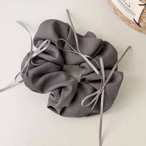 Chouchou gris foncé avec plusieurs petits nœuds en ruban pour une coiffure élégante
