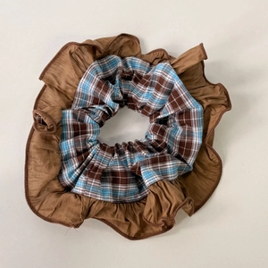 Detailed close-up of blue and brown plaid scrunchie with layered vintage ruffle edges