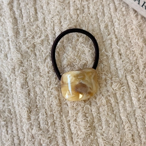 Close-up of amber marble resin hair tie with France Handmade gold lettering detail