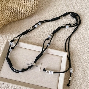 Detail of bohemian woven waist chain with silver beads and marble stones on beige fabric