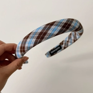 Detail of handmade padded headband with blue and brown plaid fabric and anti-slip lining