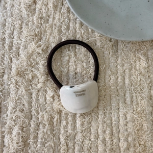 Detailed close-up of handmade white curved hair tie with France text engraving