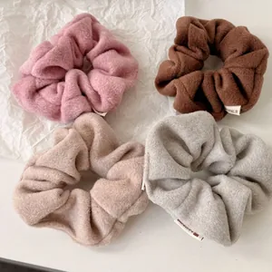 Set of four soft plush scrunchies in pink, coffee, apricot, and grey faux lamb wool fabric