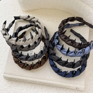 Detail of twisted fabric headbands with non-slip teeth in muted elegant tones