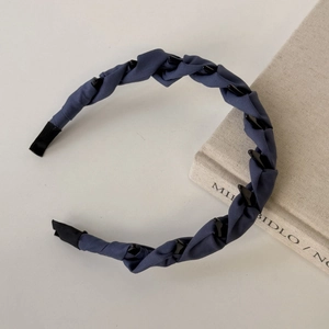 Detail of navy blue twisted fabric headband with anti-slip teeth for secure styling