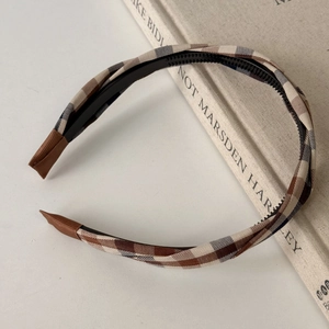 Close-up of vintage plaid headband with anti-slip inner teeth and brown ribbon ends