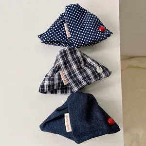 Three handmade fabric hair claws in navy blue plaid, polka dot, and denim patterns