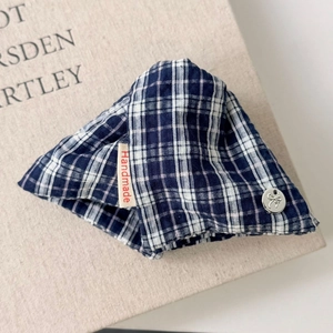 Close-up of blue plaid fabric hair claw clip with handmade label and silver button detail